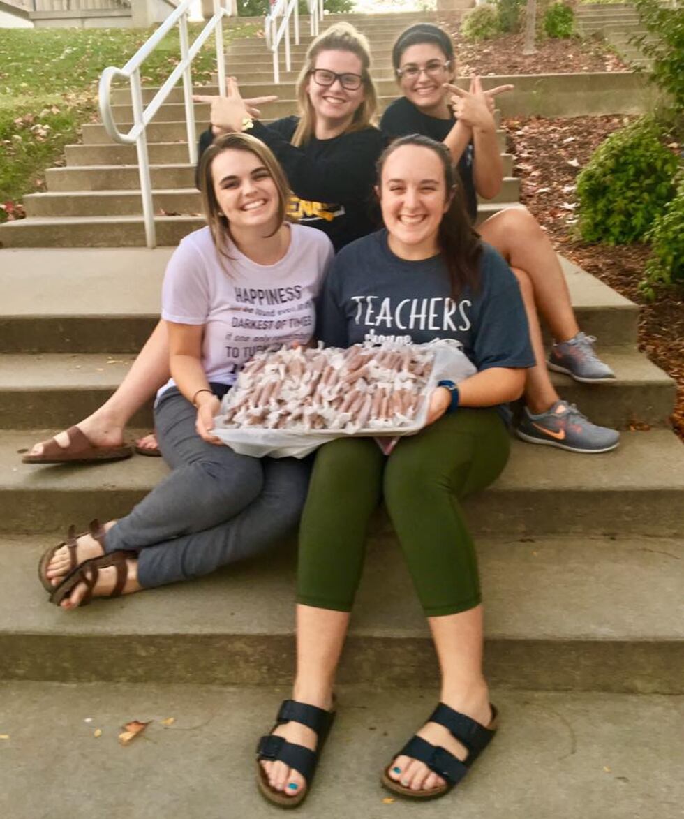 Volunteers from Southeast Missouri State University help Reinagel with her Caramels for a...