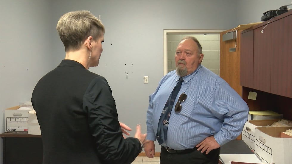 James shows Kathy Sweeney the room at the Scott County Sheriff's Office where he can access...