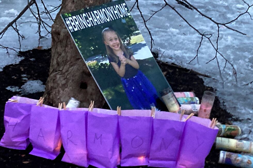 A poster of Harmony Montgomery, who has been missing since 2019, rests against a tree during a...