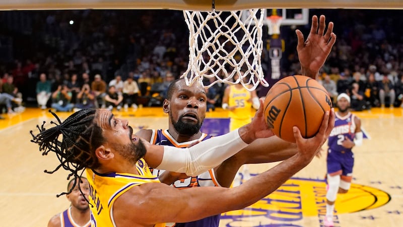 Los Angeles Lakers guard Gabe Vincent, left, shoots as Phoenix Suns forward Kevin Durant...